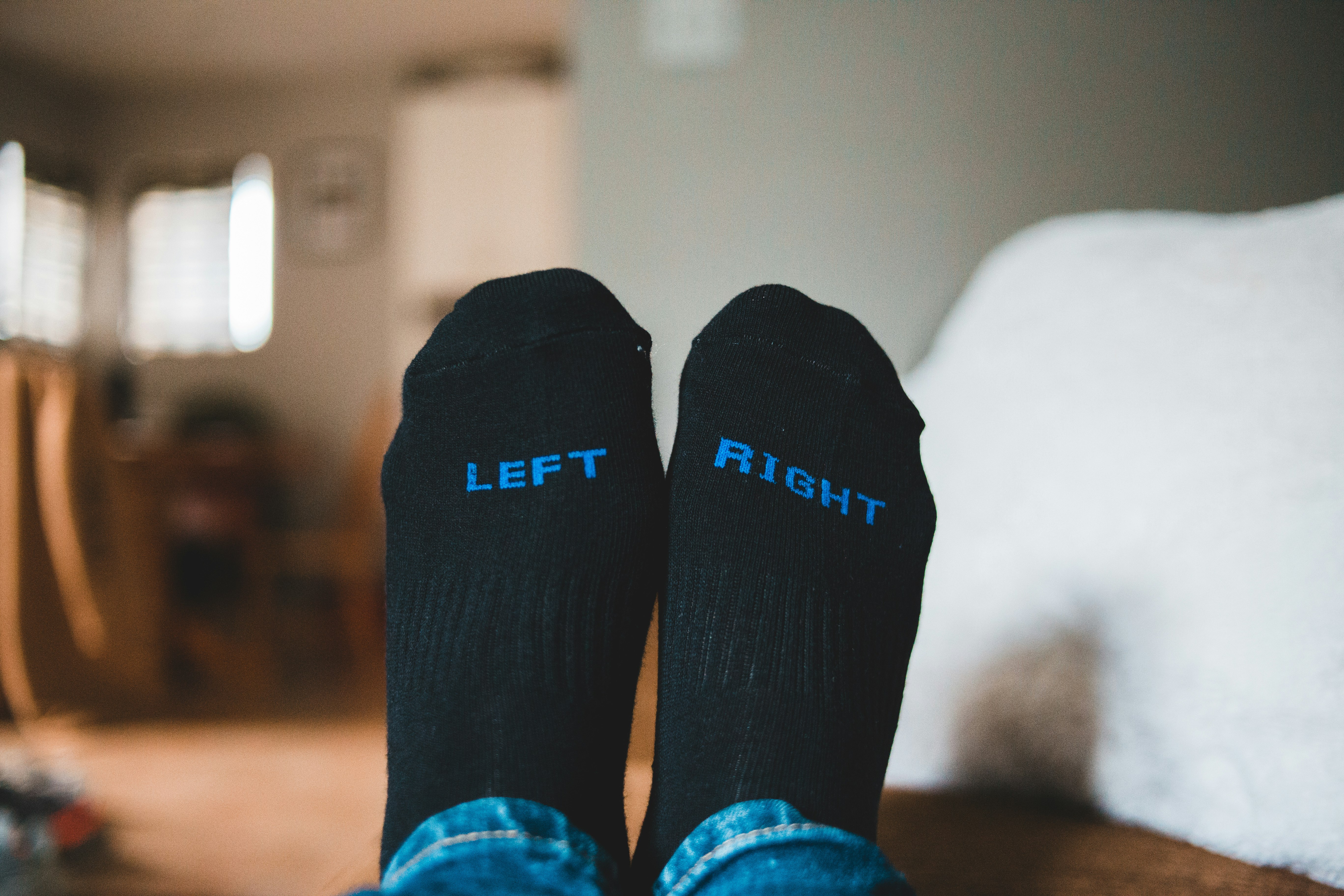 person wearing black socks on brown wooden floor